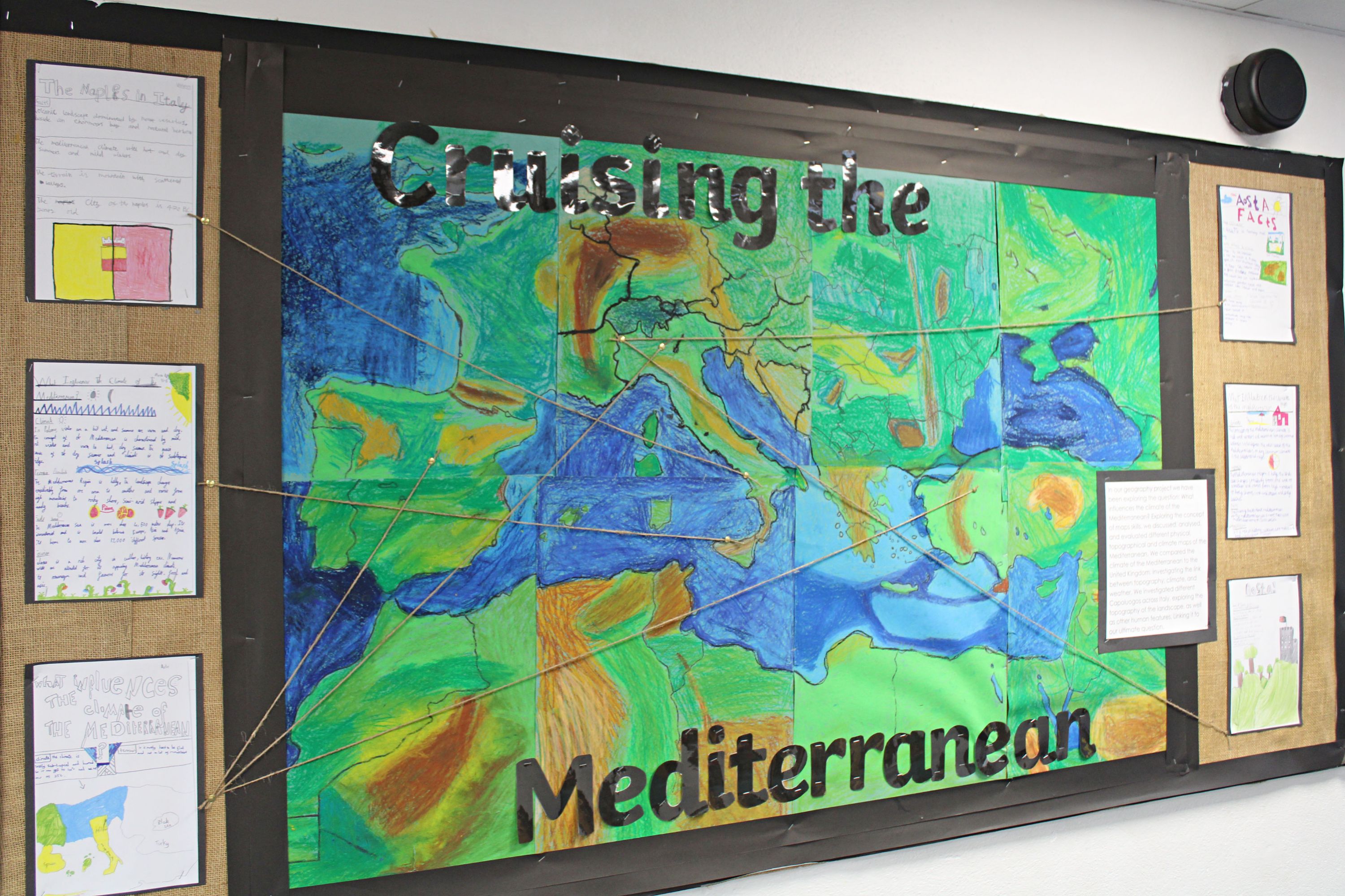 A wall display of children's geography work with a large map in the centre, titled: Crossing the Mediterranean